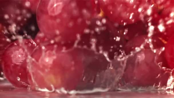 Rode Druiven Vallen Met Spatten Een Natte Tafel Gefilmd Een — Stockvideo