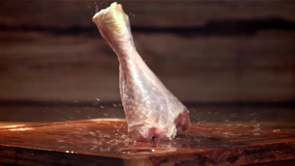 チキンの足は木製の切断板に落ちている 1000Fpsで高速カメラで撮影しました 高品質のフルHd映像 — ストック動画