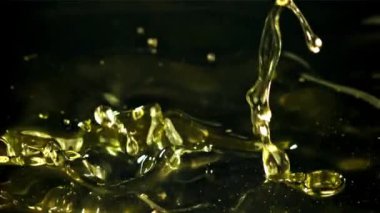 Siyah arka planda sıçramış zeytinyağı. 1000 fps 'de yüksek hızlı bir kamerayla çekildi. Yüksek kaliteli FullHD görüntüler