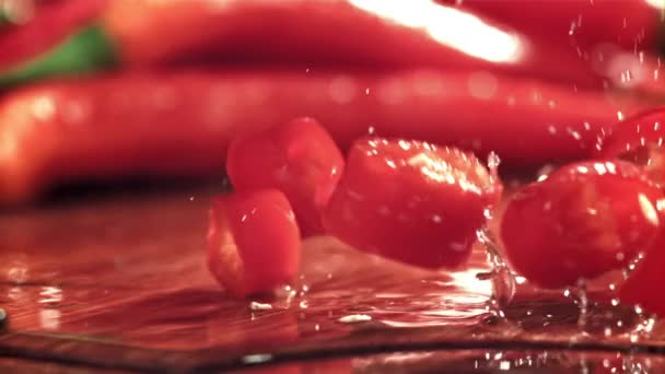 Нарезанные Кусочки Перца Чили Падают Разделочную Доску Снято Высокоскоростную Камеру — стоковое видео