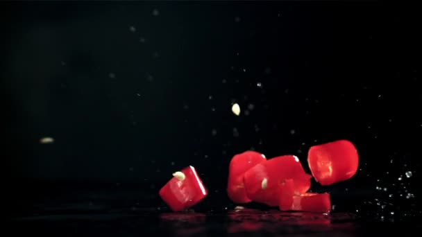 Snijd Stukjes Chili Peper Die Een Zwarte Achtergrond Vallen Gefilmd — Stockvideo