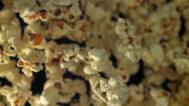 Popcorn Vliegt Omhoog Valt Naar Beneden Een Zwarte Achtergrond Gefilmd — Stockvideo