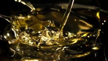 Siyah arka planda sıçramış zeytinyağı. 1000 fps 'de yüksek hızlı bir kamerayla çekildi. Yüksek kaliteli FullHD görüntüler