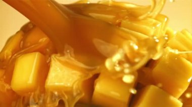 Meyve suyu dilimlenmiş mango meyvesinin içinden akar. 1000 fps 'de yüksek hızlı bir kamerayla çekildi. Yüksek kaliteli FullHD görüntüler