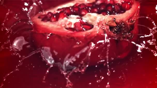 Ein Teil Des Granatapfels Fällt Mit Spritzern Den Saft Gefilmt — Stockvideo