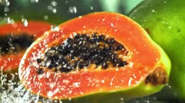 Damlaları ve su damlalarıyla taze tropikal papaya. 1000 fps 'de yüksek hızlı bir kamerayla çekildi. Yüksek kaliteli FullHD görüntüler