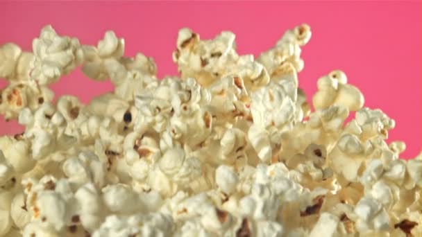 Popcorn Vliegt Omhoog Valt Naar Beneden Een Roze Achtergrond Gefilmd — Stockvideo