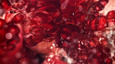 Taze meyve suyu nar suyundan akıyor. 1000 fps 'de yüksek hızlı bir kamerayla çekildi. Yüksek kaliteli FullHD görüntüler
