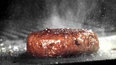 Doğal etten yapılmış bir hamburger kızartma tavasında kızarır. 1000 fps 'de yüksek hızlı bir kamerayla çekildi. Yüksek kaliteli FullHD görüntüler