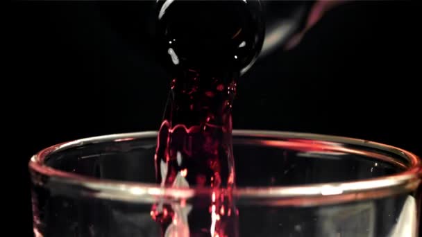 Rode Wijn Giet Een Glas Een Zwarte Achtergrond Gefilmd Een — Stockvideo