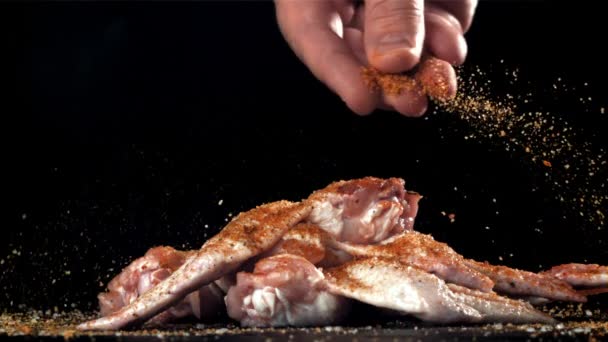 Bumbu Jatuh Pada Sayap Ayam Mentah Difilmkan Pada Kamera Berkecepatan — Stok Video