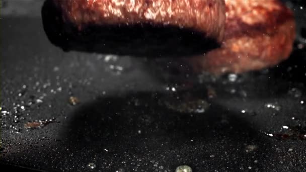 Ein Rindfleisch Burger Fällt Mit Einem Spritzer Eine Heiße Pfanne — Stockvideo