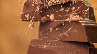 Rendelenmiş çikolata, çikolata dilimlerinin üzerine düşer. 1000 fps 'de yüksek hızlı bir kamerayla çekildi. Yüksek kaliteli FullHD görüntüler