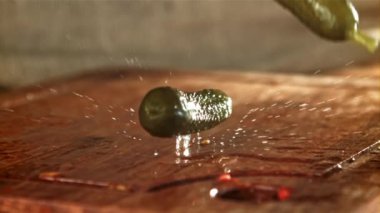 Salatalık turşusu ahşap bir masaya düşer. 1000 fps 'de yüksek hızlı bir kamerayla çekildi. Yüksek kaliteli FullHD görüntüler