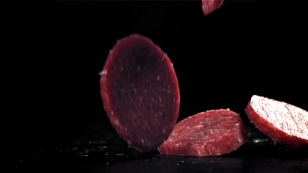 Gesneden Salami Valt Zwarte Achtergrond Gefilmd Een Hoge Snelheidscamera Met — Stockvideo