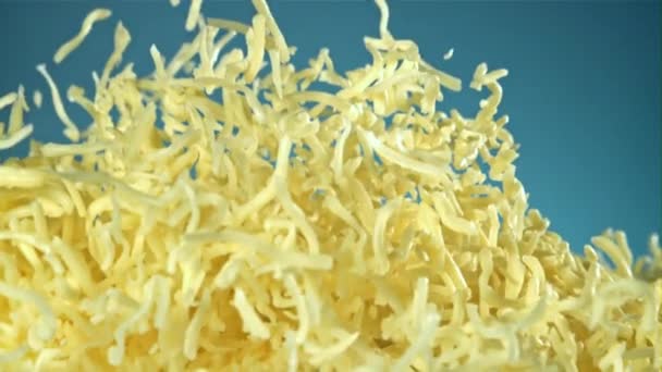 Versnipperde Kaas Vliegt Omhoog Een Blauwe Achtergrond Gefilmd Een Hoge — Stockvideo