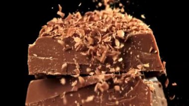 Rendelenmiş çikolata, çikolata dilimlerinin üzerine düşer. 1000 fps 'de yüksek hızlı bir kamerayla çekildi. Yüksek kaliteli FullHD görüntüler
