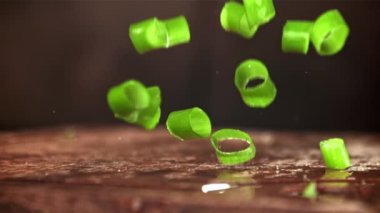 Doğranmış yeşil soğanlar kesme tahtasına düşer. 1000 fps 'de yüksek hızlı bir kamerayla çekildi. Yüksek kaliteli FullHD görüntüler
