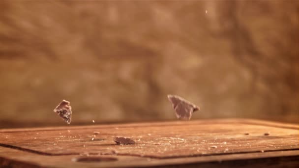 Pedazos Chocolate Caen Sobre Una Mesa Madera Filmado Una Cámara — Vídeo de stock