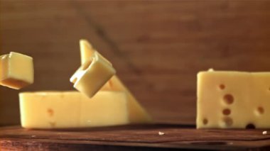 Süper yavaş çekim peynir parçaları kesme tahtasına düşer. 1000 fps 'de yüksek hızlı bir kamerayla çekildi. Yüksek kaliteli FullHD görüntüler