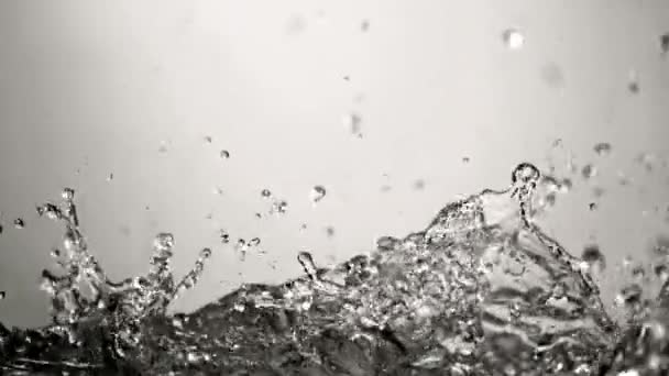透明なガラスの表面にスプラッシュする水滴のクローズアップショット — ストック動画