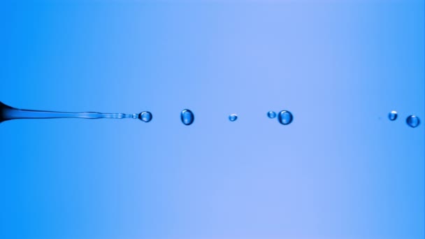 Una Gota Líquido Desciende Una Pipeta Sobre Una Superficie Azul — Vídeos de Stock