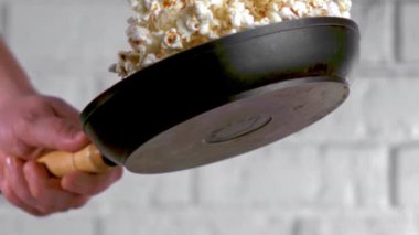 Beyaz tuğla duvar zemininde patlamış mısırla eğlenceli etkileşimler gösteren yaratıcı bir video. Mutfak yaratıcılığının dokunuşuyla eğlenceli ve kaprisli unsurlar içeriyor.