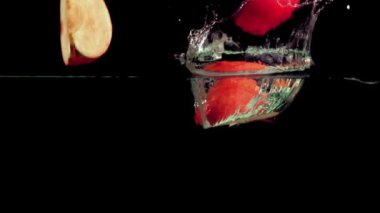 Süper yavaş çekimde kırmızı elmalar suya su sıçratarak düşer. 1000 fps 'de yüksek hızlı bir kamerayla çekildi. Yüksek kaliteli FullHD görüntüler
