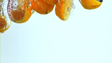 Süper yavaş çekimde limon parçaları hava kabarcıklarıyla suya düşer. 1000 fps 'de yüksek hızlı bir kamerayla çekildi. Yüksek kaliteli FullHD görüntüler