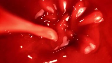 Süper yavaş çekimde domates suyu dökülüyor. 1000 fps 'de yüksek hızlı bir kamerayla çekildi. Yüksek kaliteli FullHD görüntüler