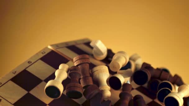 Een Verzameling Houten Schaakstukken Rustend Een Schaakbord Tegen Een Gele — Stockvideo