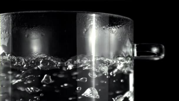 Een Glas Water Kookt Een Pot Een Zwarte Achtergrond Waardoor — Stockvideo