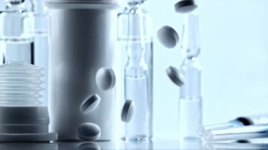 İlaçlar masaya düşer. Beyaz bir arkaplanda. Saniyede yavaş çekim 1000 kare. Yüksek kaliteli FullHD görüntüler