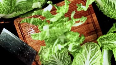 Pekin lahanasının süper yavaş çekim parçaları kesim tahtasına düşüyor. Yüksek kaliteli FullHD görüntüler