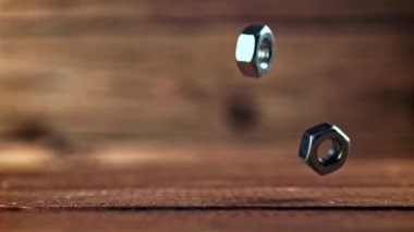 Süper yavaş çekimde metal fındıklar ahşap masaya düşer. Yüksek kaliteli FullHD görüntüler