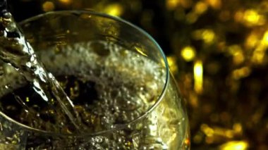 Süper yavaş çekimde şampanya hava kabarcıkları olan bir bardağa dökülür. Yüksek kaliteli FullHD görüntüler