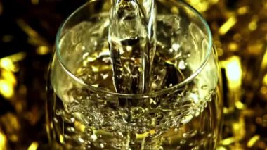 Süper yavaş çekimde şampanya hava kabarcıkları olan bir bardağa dökülür. Yüksek kaliteli FullHD görüntüler