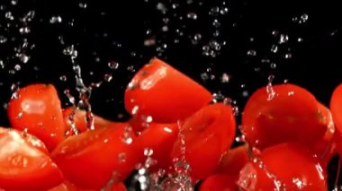 Süper yavaş çekimde domates dilimleri su damlalarıyla uçar. Yüksek kaliteli FullHD görüntüler
