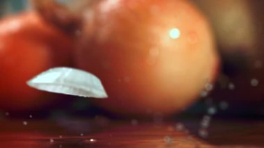 Süper yavaş çekimde dilimlenmiş soğan ıslak masaya düşer. Yüksek kaliteli FullHD görüntüler