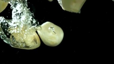 Süper yavaş çekimde sarımsak suya düşer. Yüksek kaliteli FullHD görüntüler