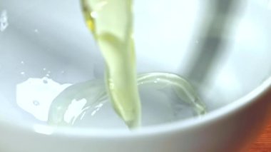 Süper yavaş çekimde çiğ yumurta bir şapkaya düşer. Yüksek kaliteli FullHD görüntüler