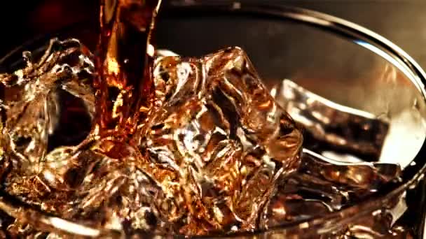 スプラッシュが付いている極度の遅い動きのウイスキーは氷のガラスに流れます 高品質のフルHd映像 — ストック動画