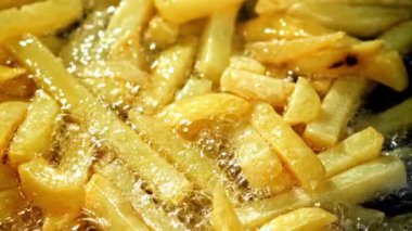 Süper yavaş çekimde patates kızartması yağda kızartılır. Yüksek kaliteli FullHD görüntüler