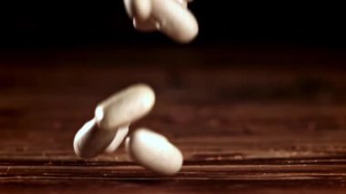 Süper yavaş çekimde beyaz fasulyeler düşüyor. Yüksek kaliteli FullHD görüntüler