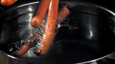 Süper yavaş çekimde sosisler tencereye düşer. Yüksek kaliteli FullHD görüntüler