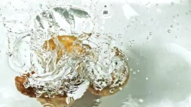 Süper yavaş hareket eden patatesler su damlatarak suya düşüyorlar. Yüksek kaliteli FullHD görüntüler