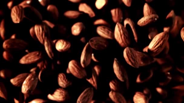 黒い背景にブラウンのアーモンドの山のクローズアップ 天然木のパターン これらの天然食品は 単一のコーヒーイベントから調達されています — ストック動画