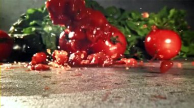 Baharatlı dilimlenmiş domatesler masaya düşer. 1000 fps 'de yüksek hızlı bir kamerayla çekildi. Yüksek kaliteli FullHD görüntüler
