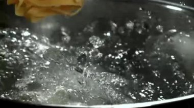 Tagliatelle makarnası kaynayan suya düşer. 1000 fps 'de yüksek hızlı bir kamerayla çekildi. Yüksek kaliteli FullHD görüntüler