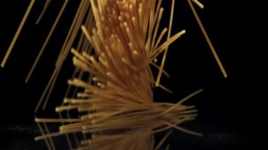 Siyah arka plana düşen kuru bir spagetti. 1000 fps 'de yüksek hızlı bir kamerayla çekildi. Yüksek kaliteli FullHD görüntüler